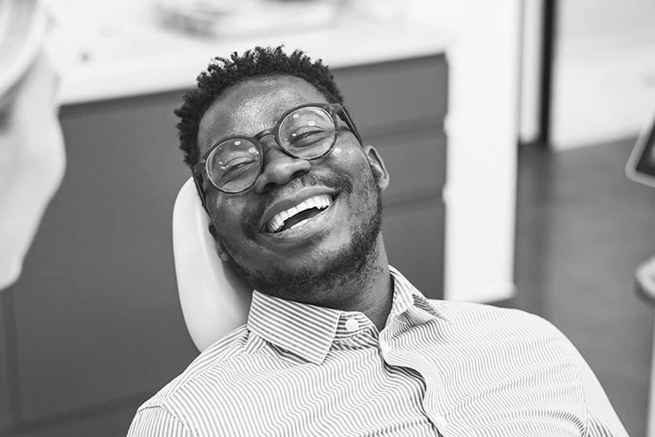 Happy-male-patient-dental-treatment Smiling patient receives dental treatment
