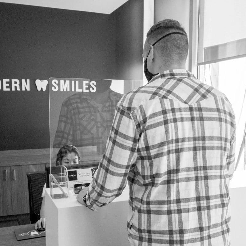 Modern-smiles-front-desk Modern smiles man at front desk