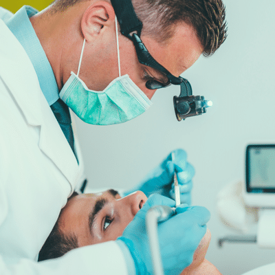 What to expect during a root canal procedure 13 Dentist working on a patient's teeth, representing root canal procedure